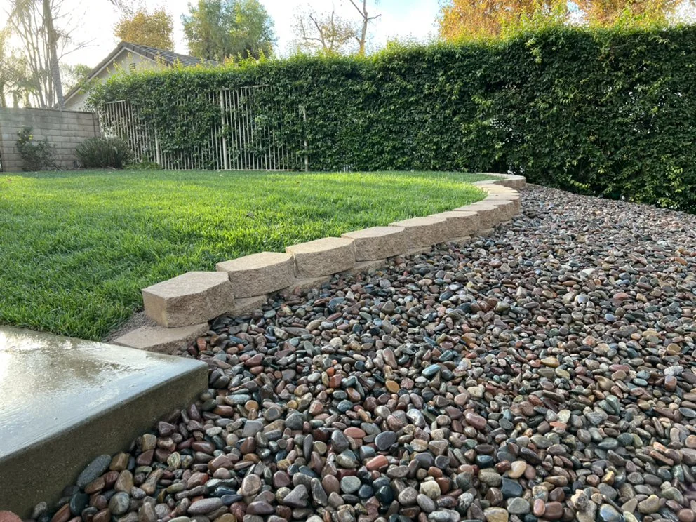 Rock-lined landscape border beside a residential lawn